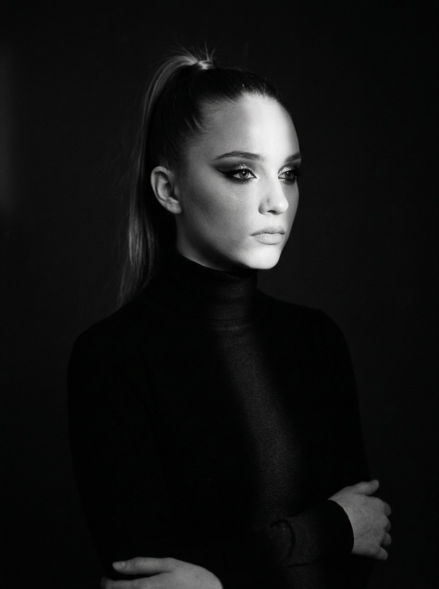 Dramatic waist-up portrait of pensive girl in the dim